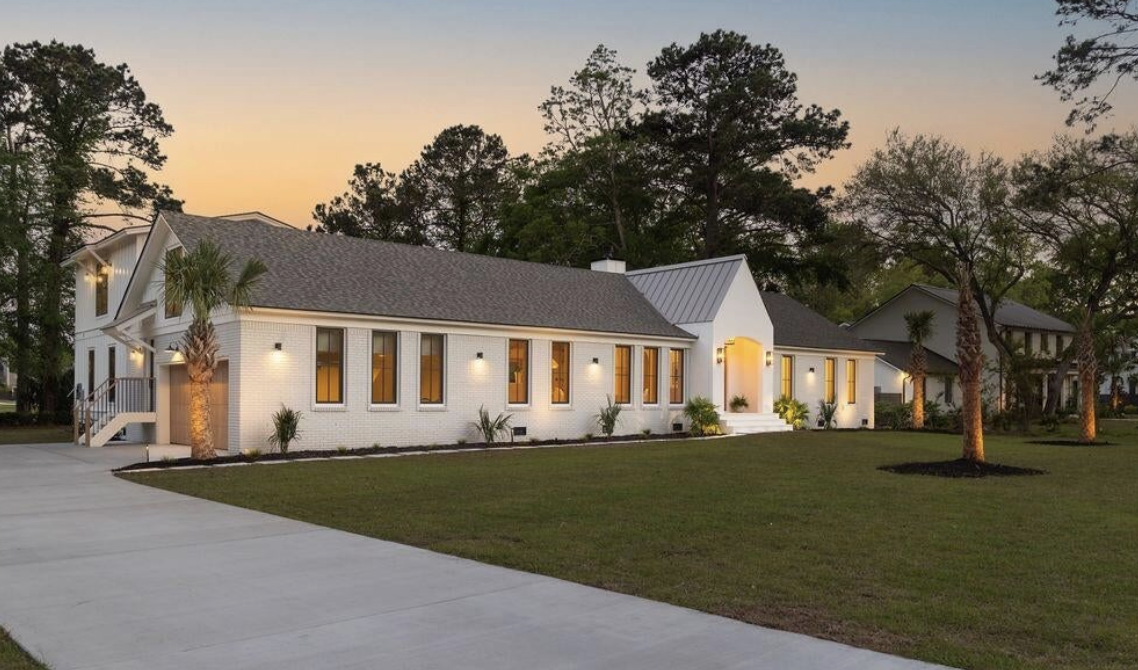 Modern white brick lowcountry home at 1183 Farm Quarter Road at golden hour