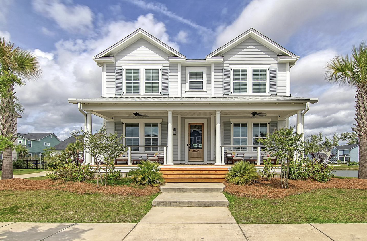 Two-story porch home at 3634 Spindrift Drive flanked by palmettos